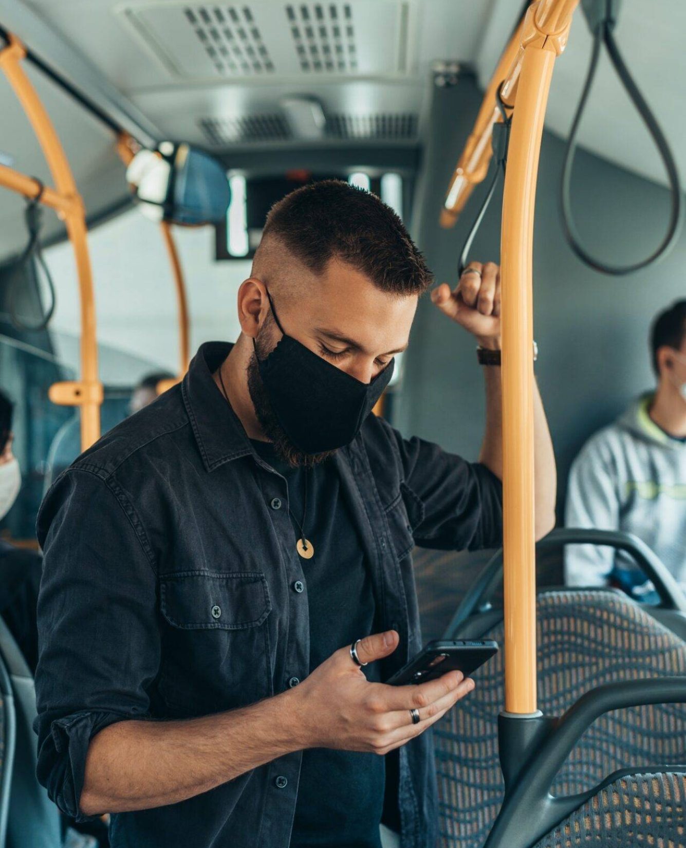 man-wearing-a-protective-mask-and-using-a-smartphone-while-keeping-the-distance-in-the-bus.jpg man-wearing-a-protective-mask-and-using-a-smartphone-while-keeping-the-distance-in-the-bus.jpg
